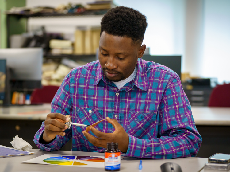 Interior design student gluing color wheel. 