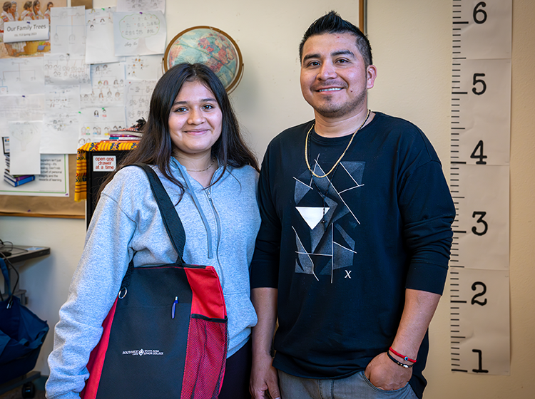 Two young students, a Latinx female and a male, are smiling at the Counseling office at SRJC Roseland. 