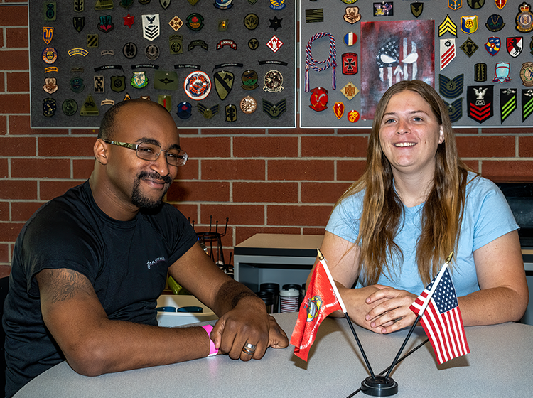 A male and a female veteran are smiling at the camera during a discussion in the Veterans Success Center at Santa Rosa Junior College.
