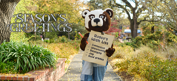 Rosco the Bear Cub, the SRJC mascot, poses against a backdrop of winter yellow foliage. The mascot holds an oversized pencil and a wish list inscribed with “Connection, opportunity, Belonging, joy, good grades.” The photo is inscribed with "Season’s Greetings."