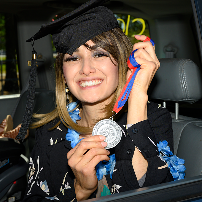 Happy Latinx woman in graduation garb